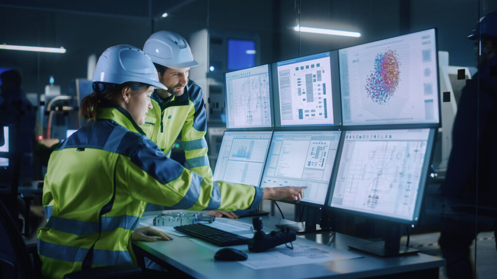 Modern Factory: Project Engineer Talks to Female Operator who Controls Facility Production Line, Uses Computer with management and operational screens.