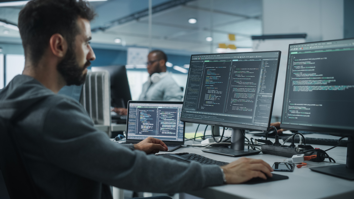 Programista IT pracujący na komputerze stacjonarnym. Specjalista Software House i IoT tworzący innowacyjne oprogramowanie. Pisanie kodu w terminalu.